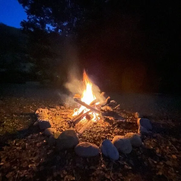 Fogata encendida al anochecer, fuera de la ciudad